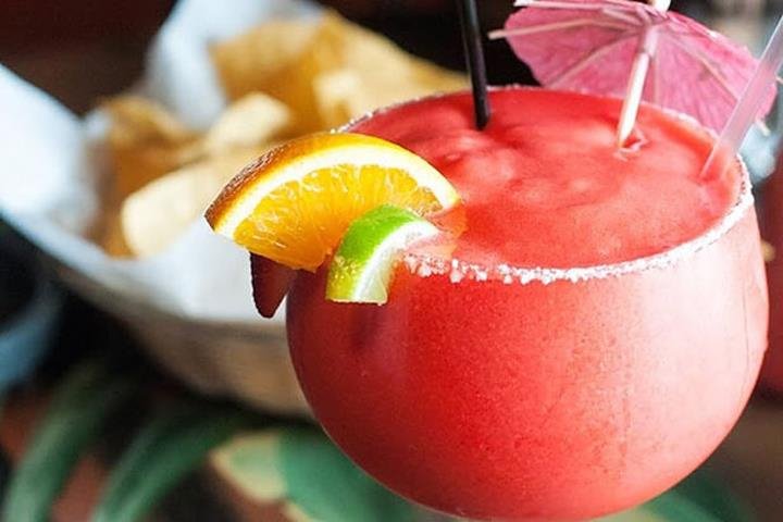A big frozen margarita with orange and lime garnish at Los Agaves' cantina