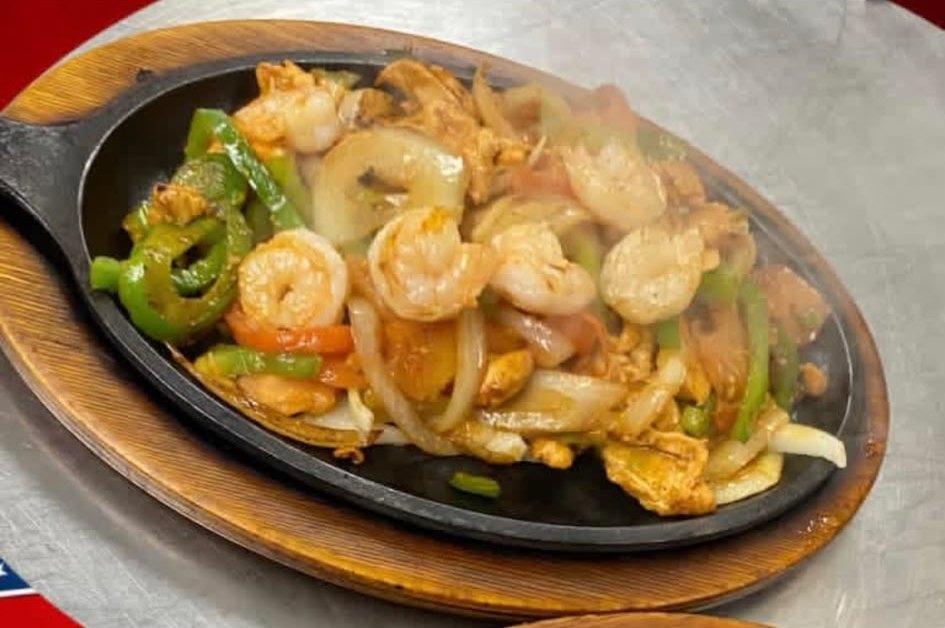 A sizzling chicken and shrimp fajitas skillet at Los Agaves