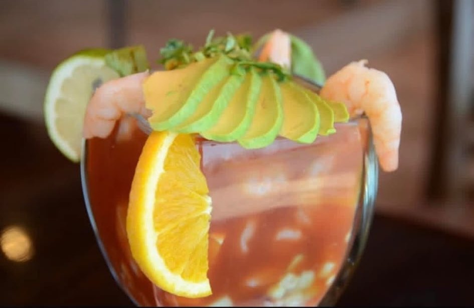 Shrimp cocktail topped with avocado, orange and lime